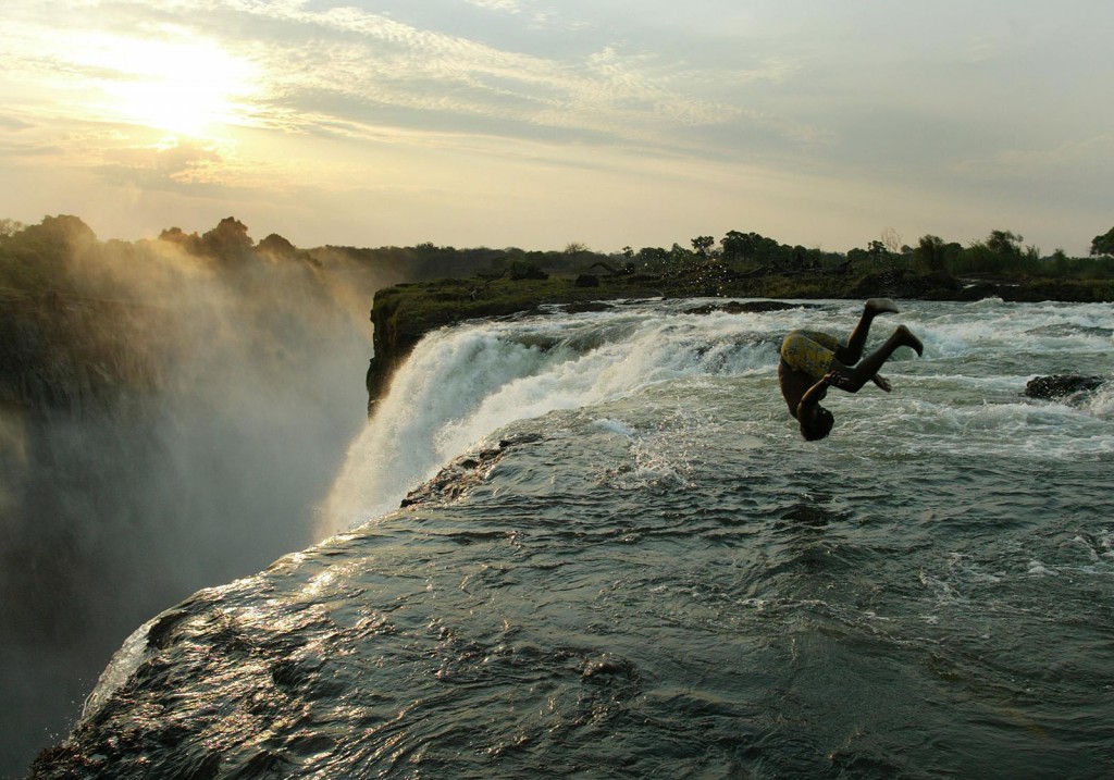 Zambian man somersaults into a pool at edge of Victoria Falls on the Zambezi River